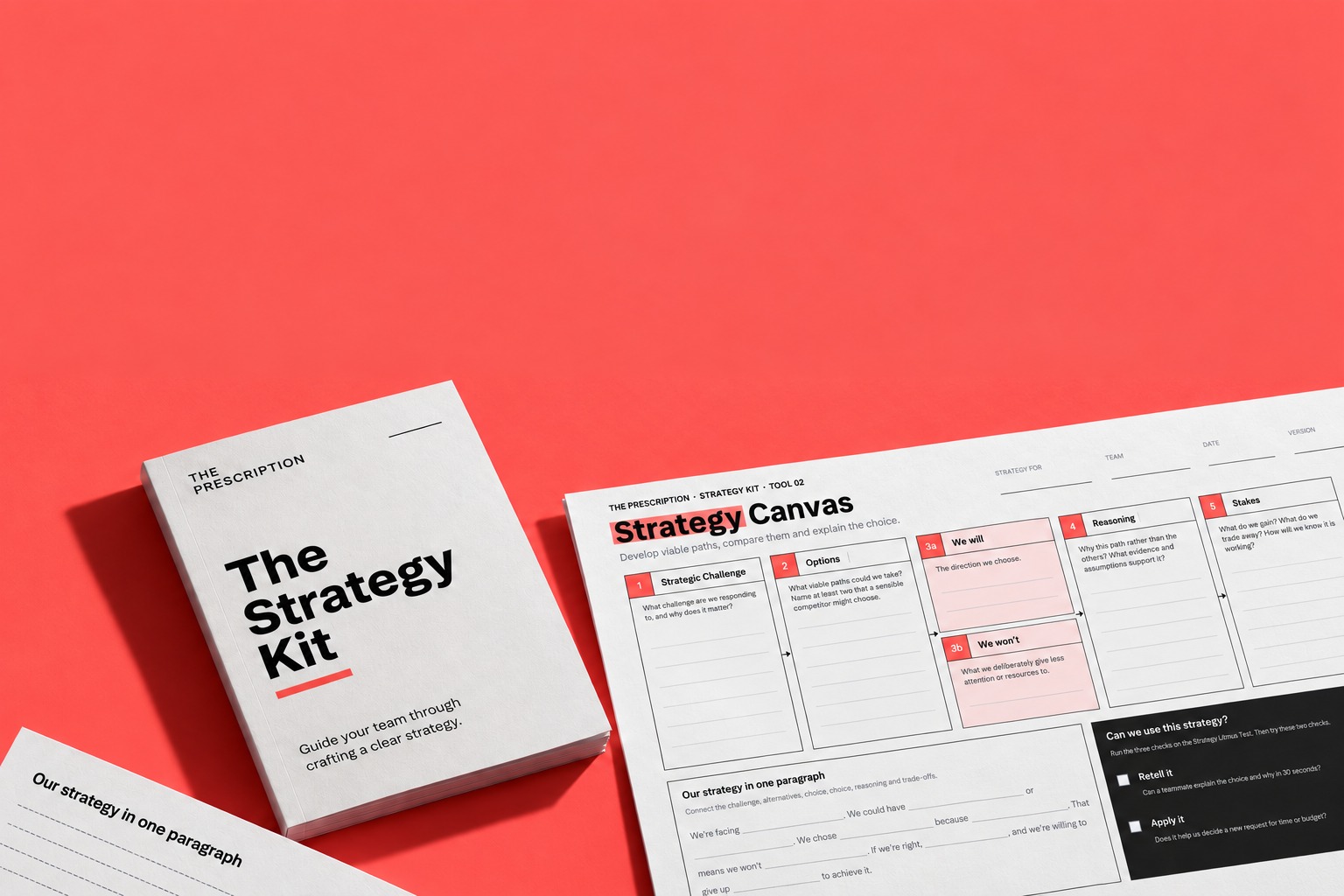 The Strategy Kit shown as printed workshop materials on a coral surface