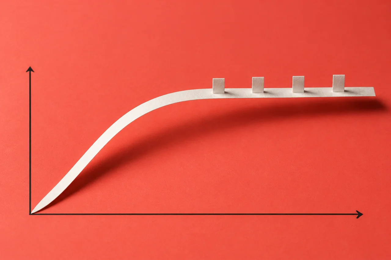 A white paper curve rises then flattens across a coral surface, with four small tabs along its flat section.